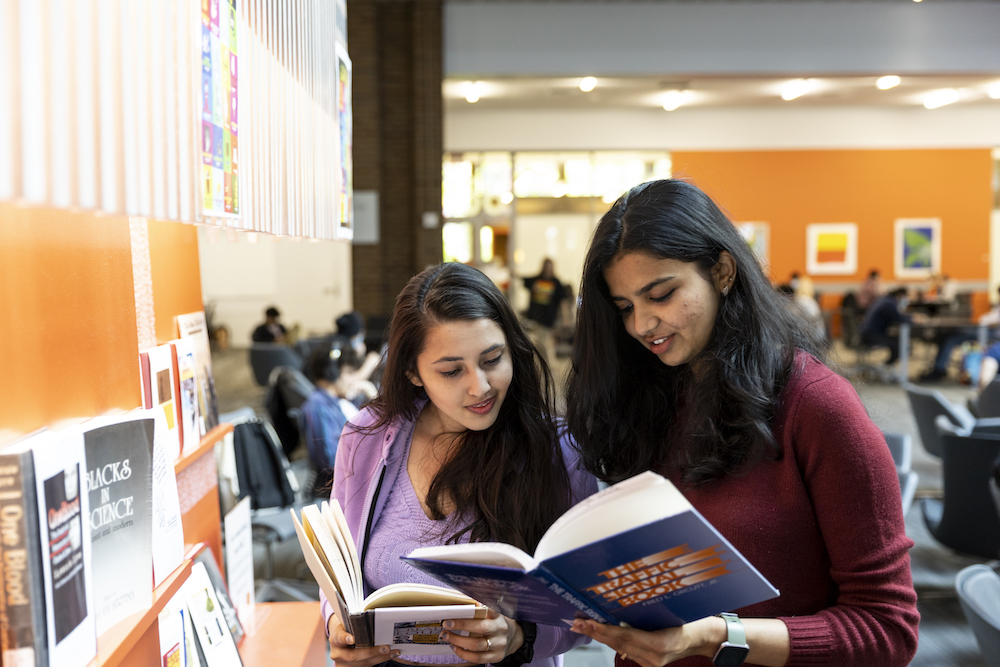 Students looking at books together in the library